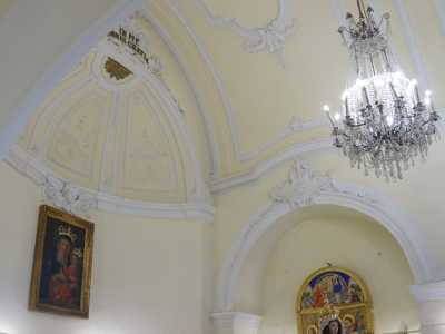 Varchiamo ora il portale maggiore, per ritrovarci all�interno di un piccolo ambiente chiuso da un soffitto color avorio puntellato da decorazioni floreali bianche da cui scende un moderno lampadario in vetro